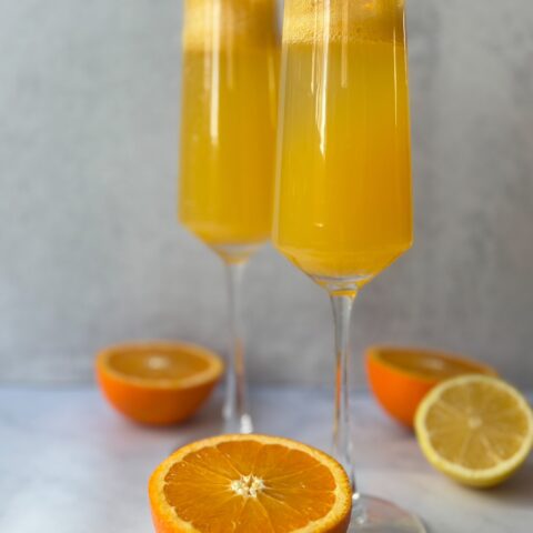 Mimosa mocktail finished with oranges.