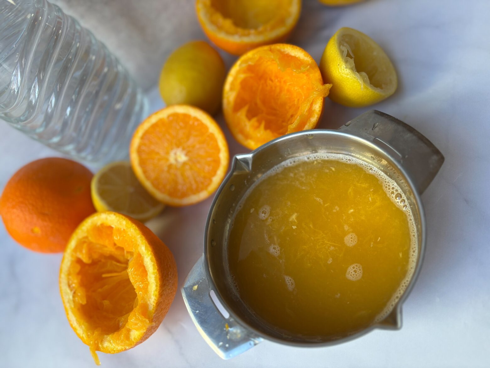Mimosa mocktail prep with juice in the juicer.