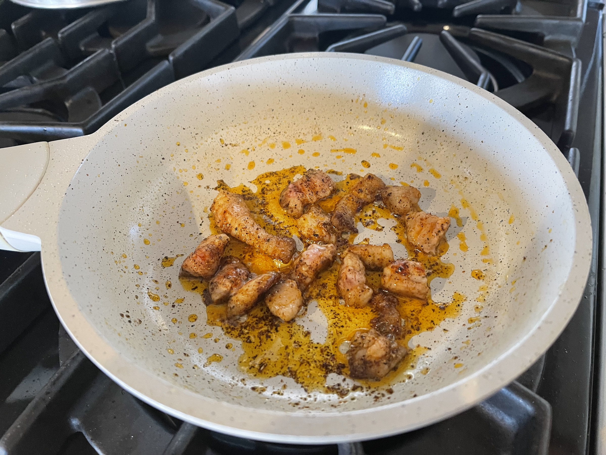 Pork belly cooking in a pan from far away.