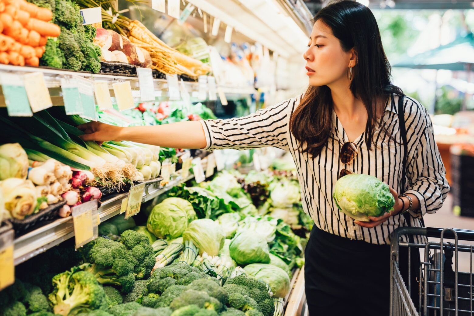 Women food shopping in the produce section.