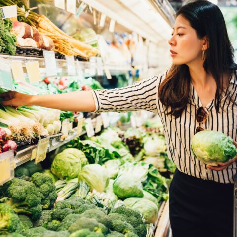 Women food shopping in the produce section.