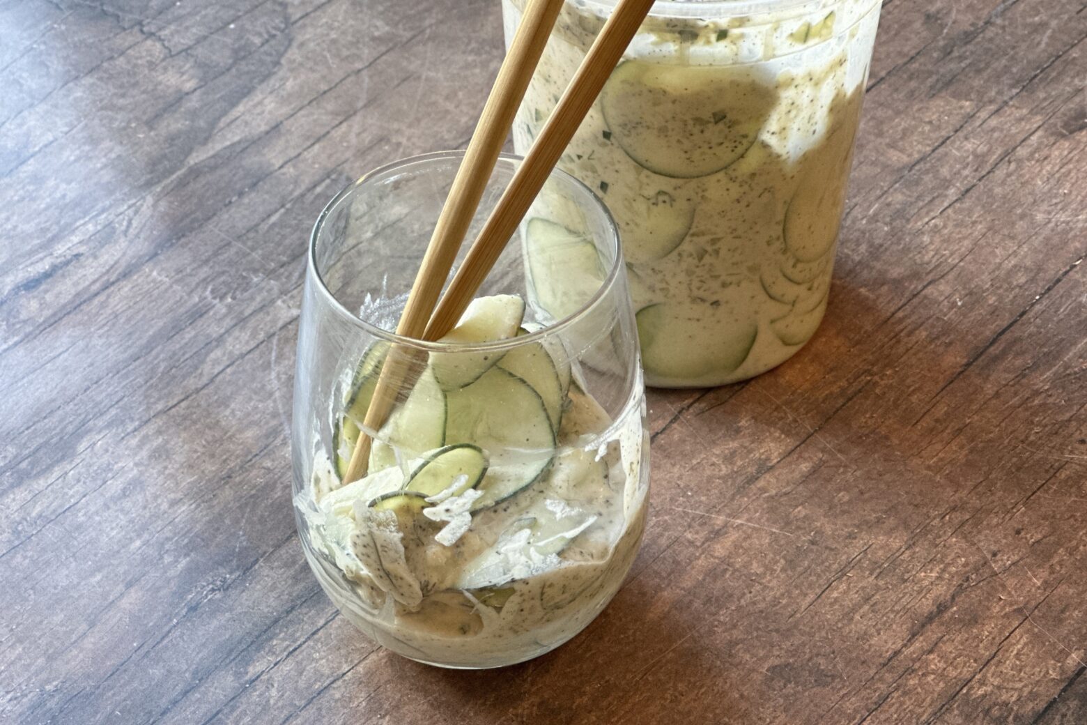 Finished Cucumber Salad in a glass with chopsticks