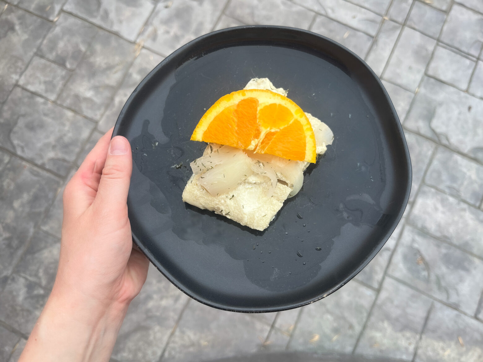 Orange poached halibut fish finished on a plate.