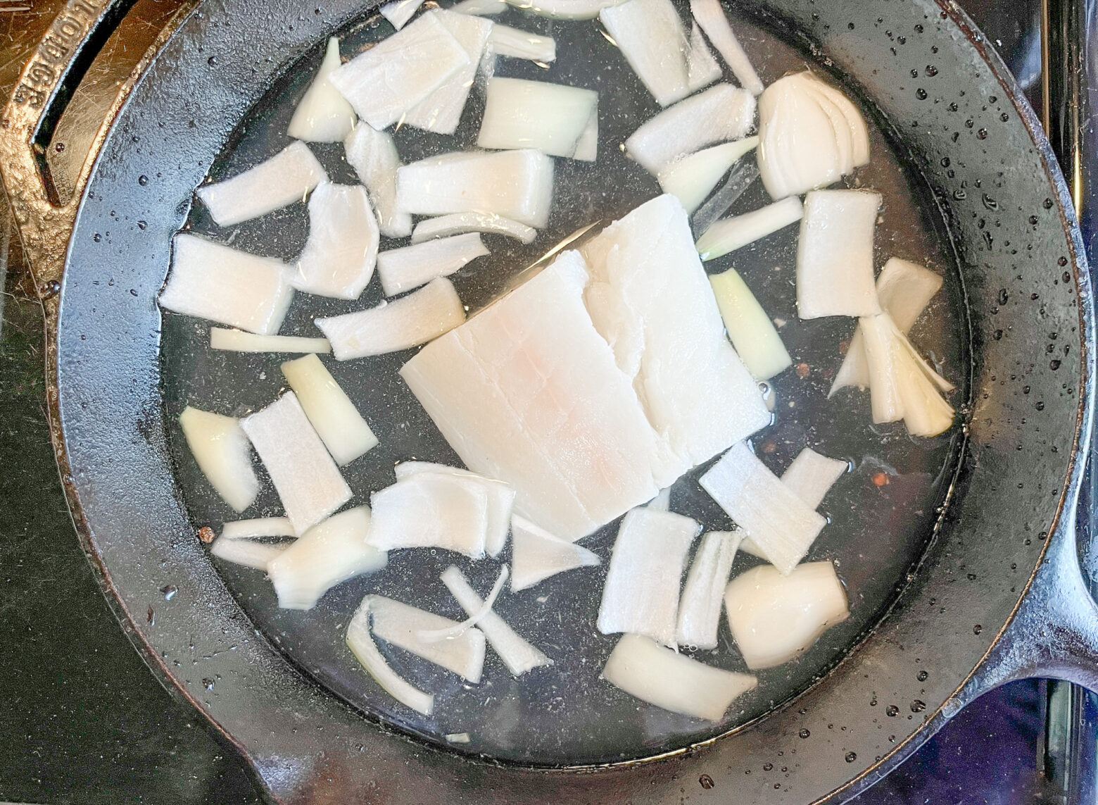 Orange poached halibut in the cast iron over the stove.