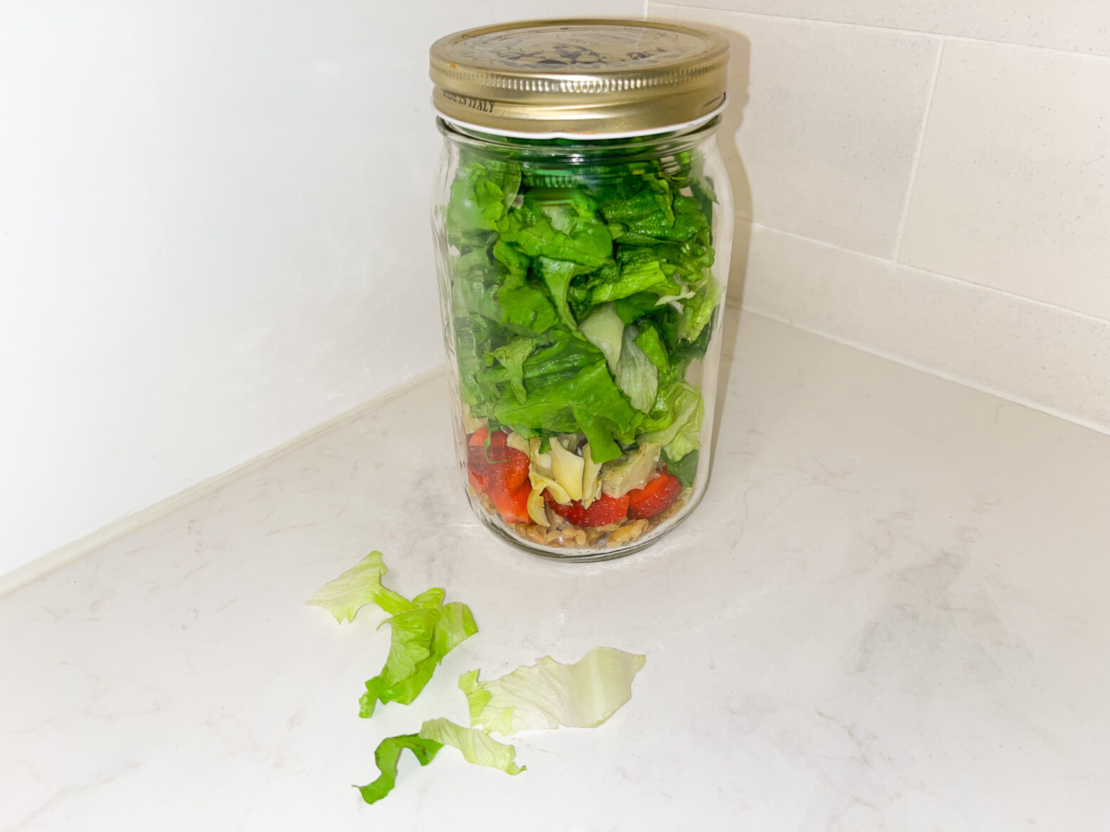 Spring mason jar salad finished on the counter top.
