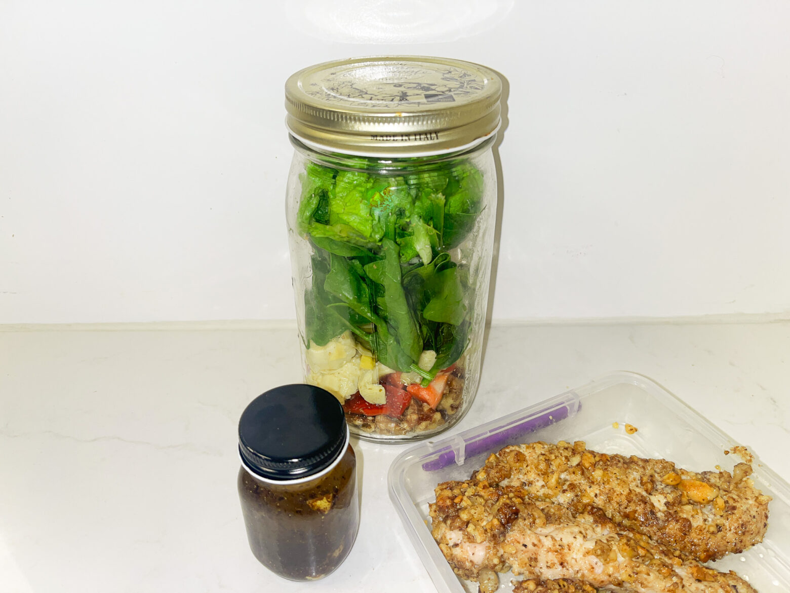 Spring mason jar salad prep finished and separated into containers.