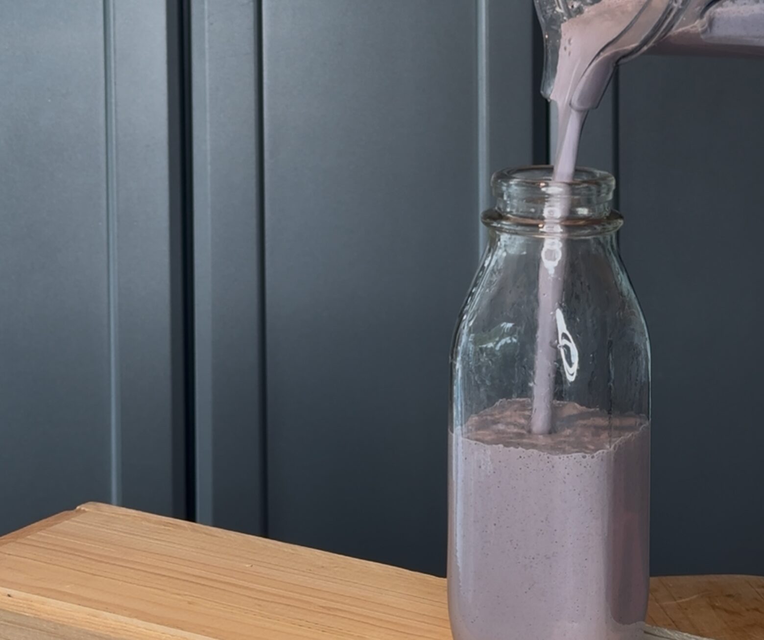 Vegan protein shake being poured into a jar.
