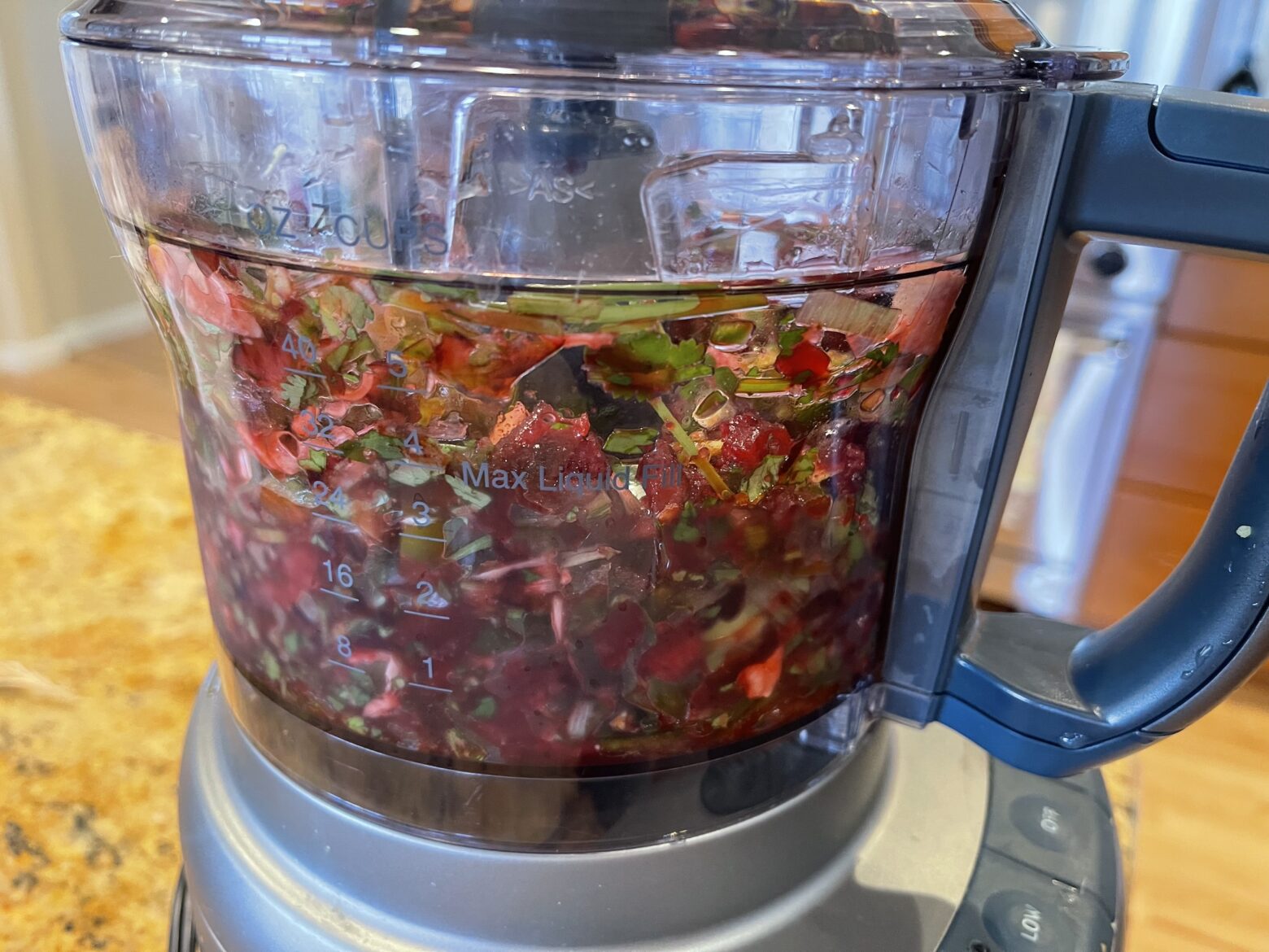 Cherry salsa from a side view in a food processor.