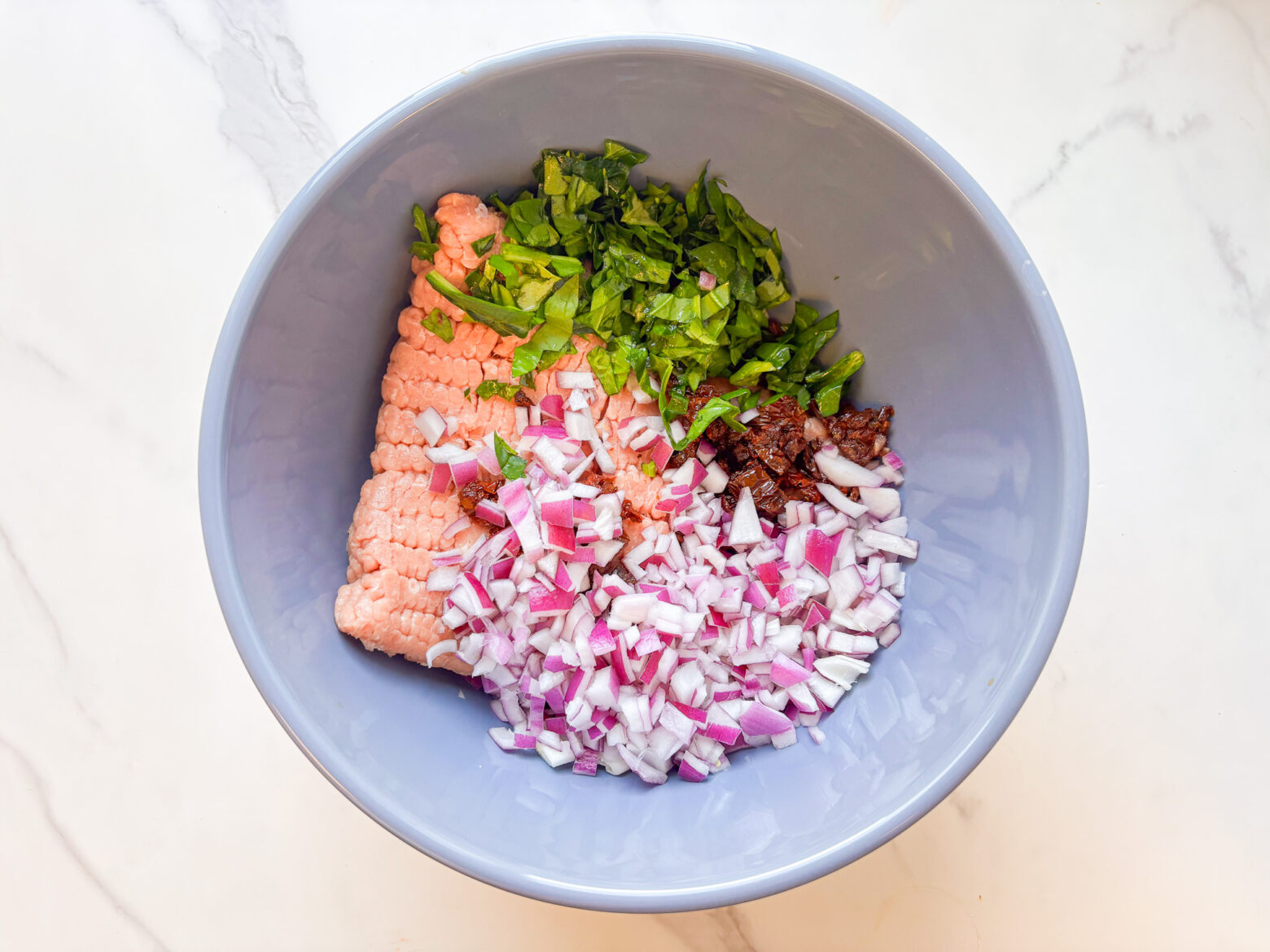 Spinach turkey burgers in a mixing bowl, unmixed.
