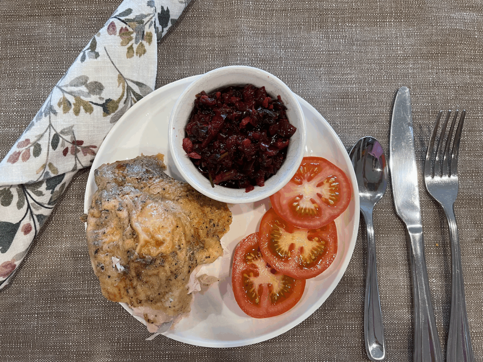 Cherry salsa paired with chicken and tomatoes on a plate.