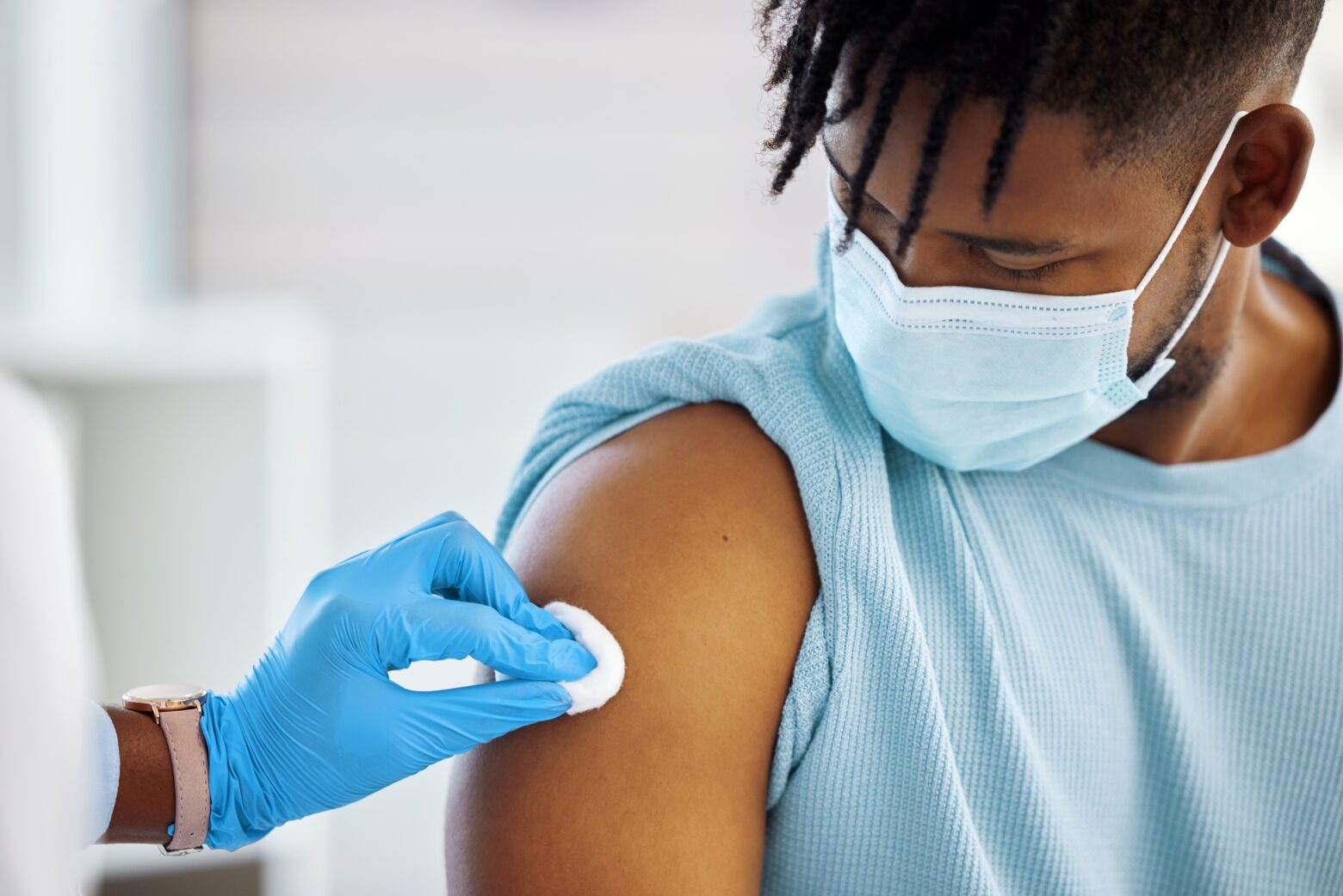 Young man getting his arm swabbed with alcohol to prep for a vaccination