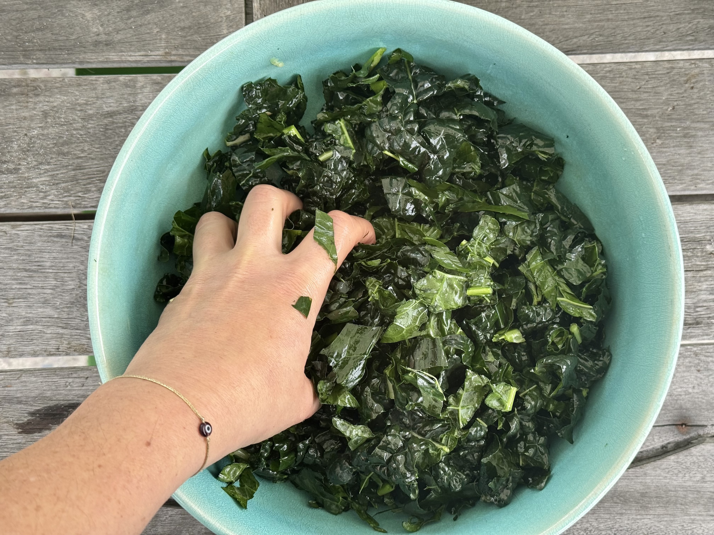 Kale sweet potato salad preparation with kale in a bowl. 