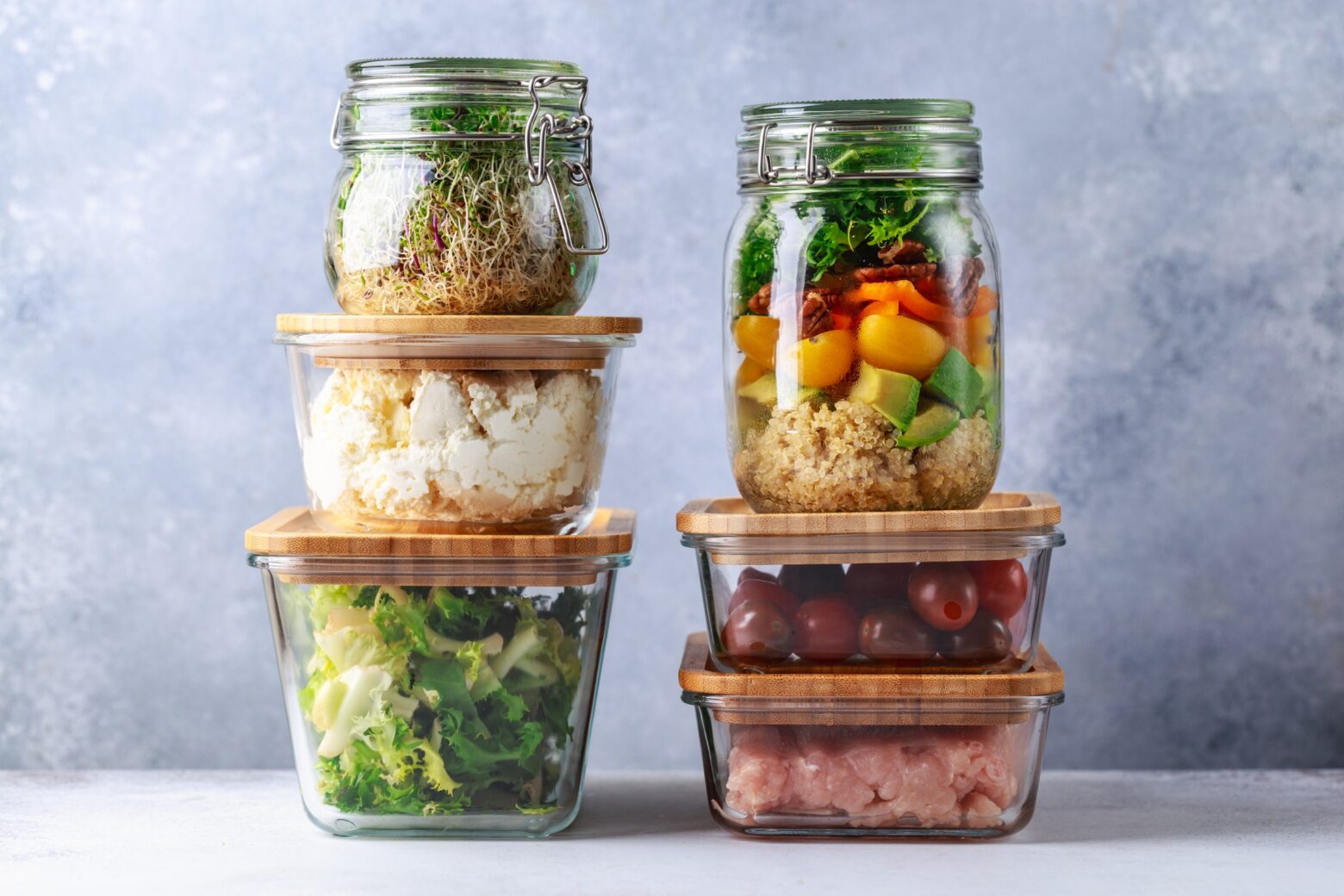 Stacked glass containers with prepped lunch meals.
