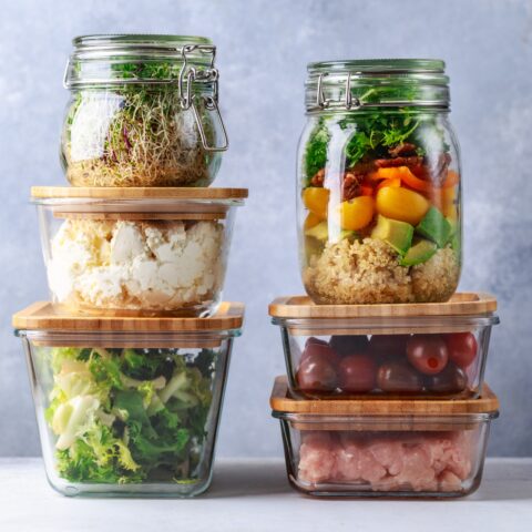 Stacked glass containers with prepped lunch meals.