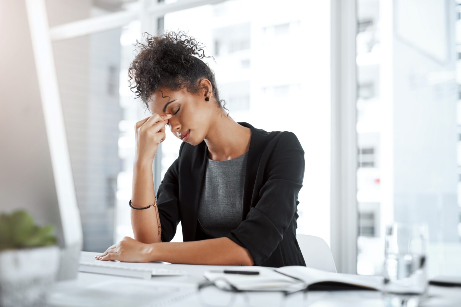 Woman suffering from a migraine while at work