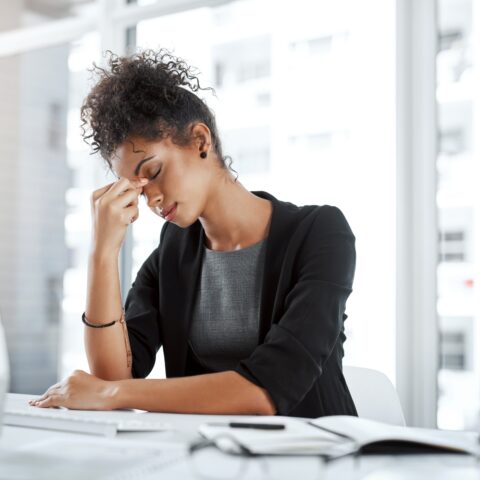Woman suffering from a migraine while at work