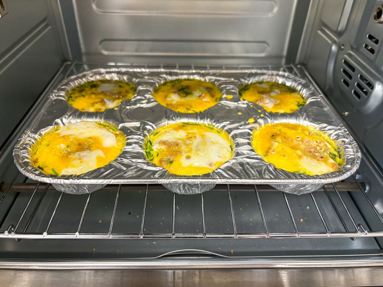 Okra egg bites being cooked in the oven in a muffin tin.