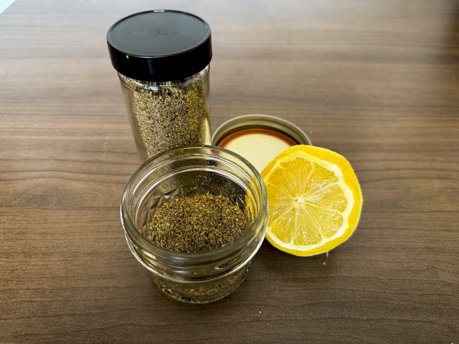 Final photo of lemon pepper seasoning in jars with halved lemon