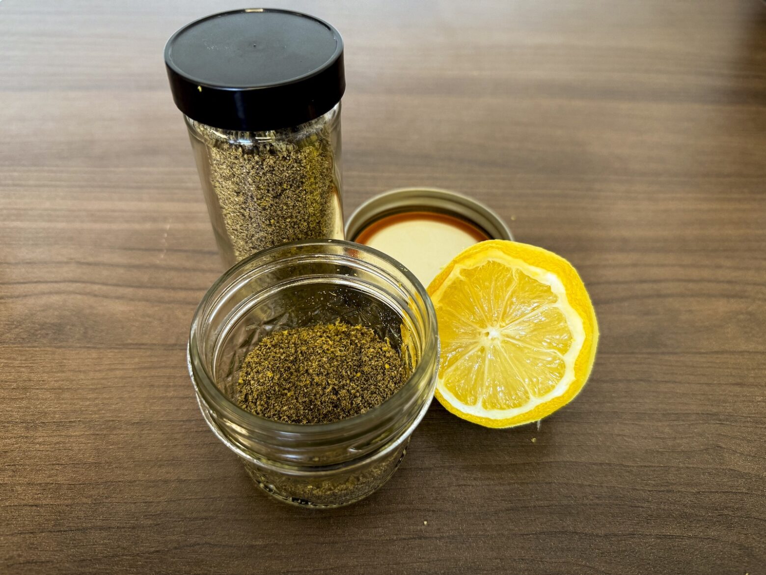 Final photo of lemon pepper seasoning in jars with halved lemon