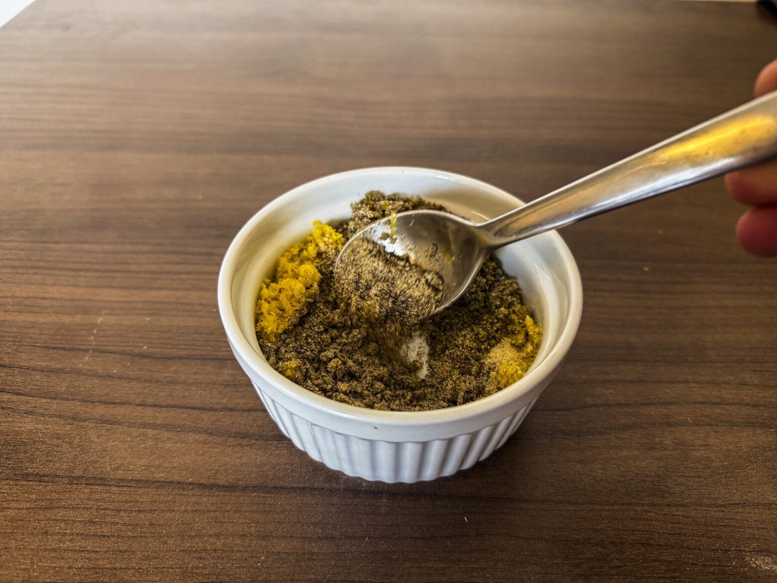 Prep photo of actively mixing seasonings with lemon zest in bowl