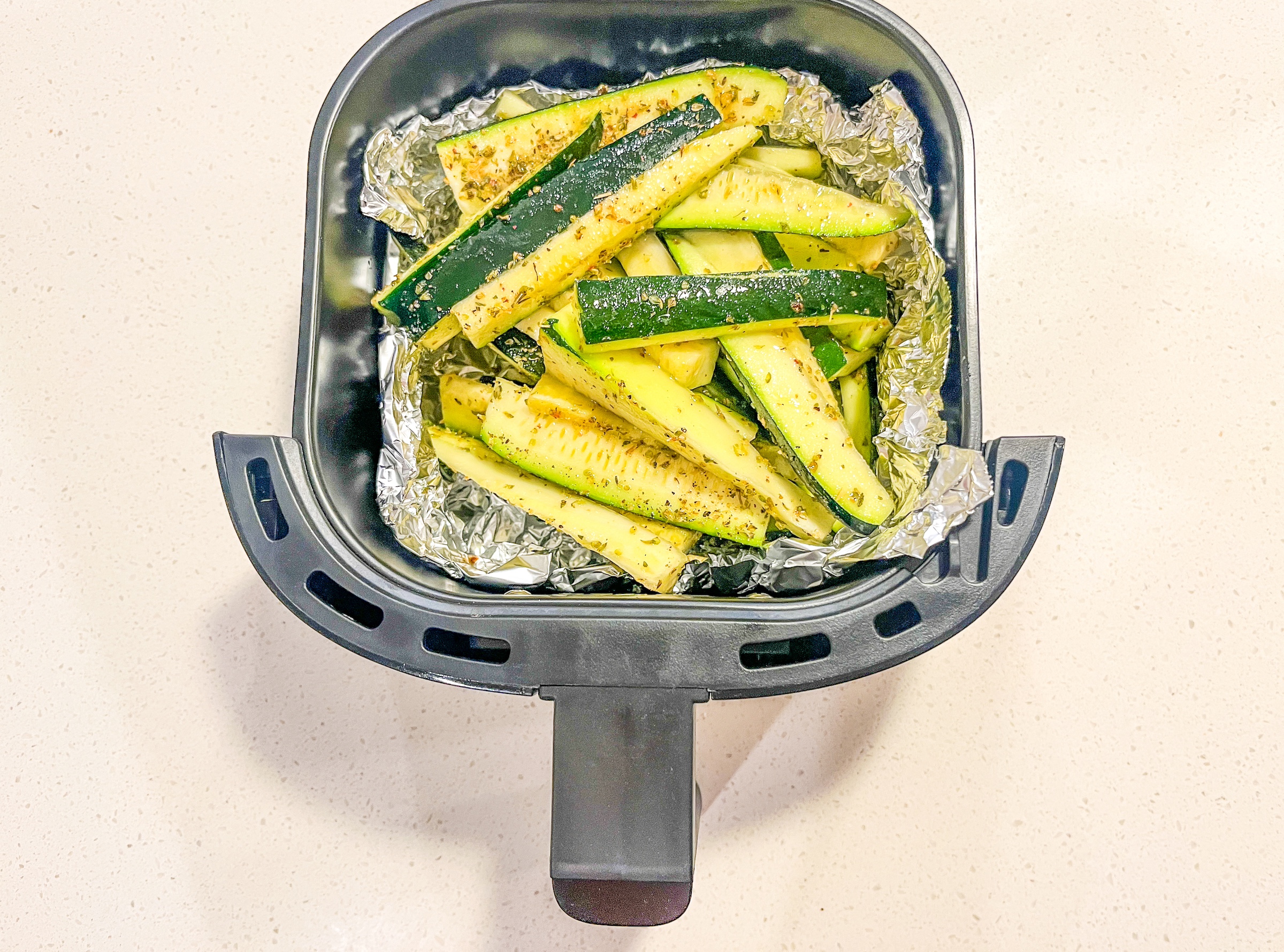 Air fryer zucchini in the air fryer basket. 