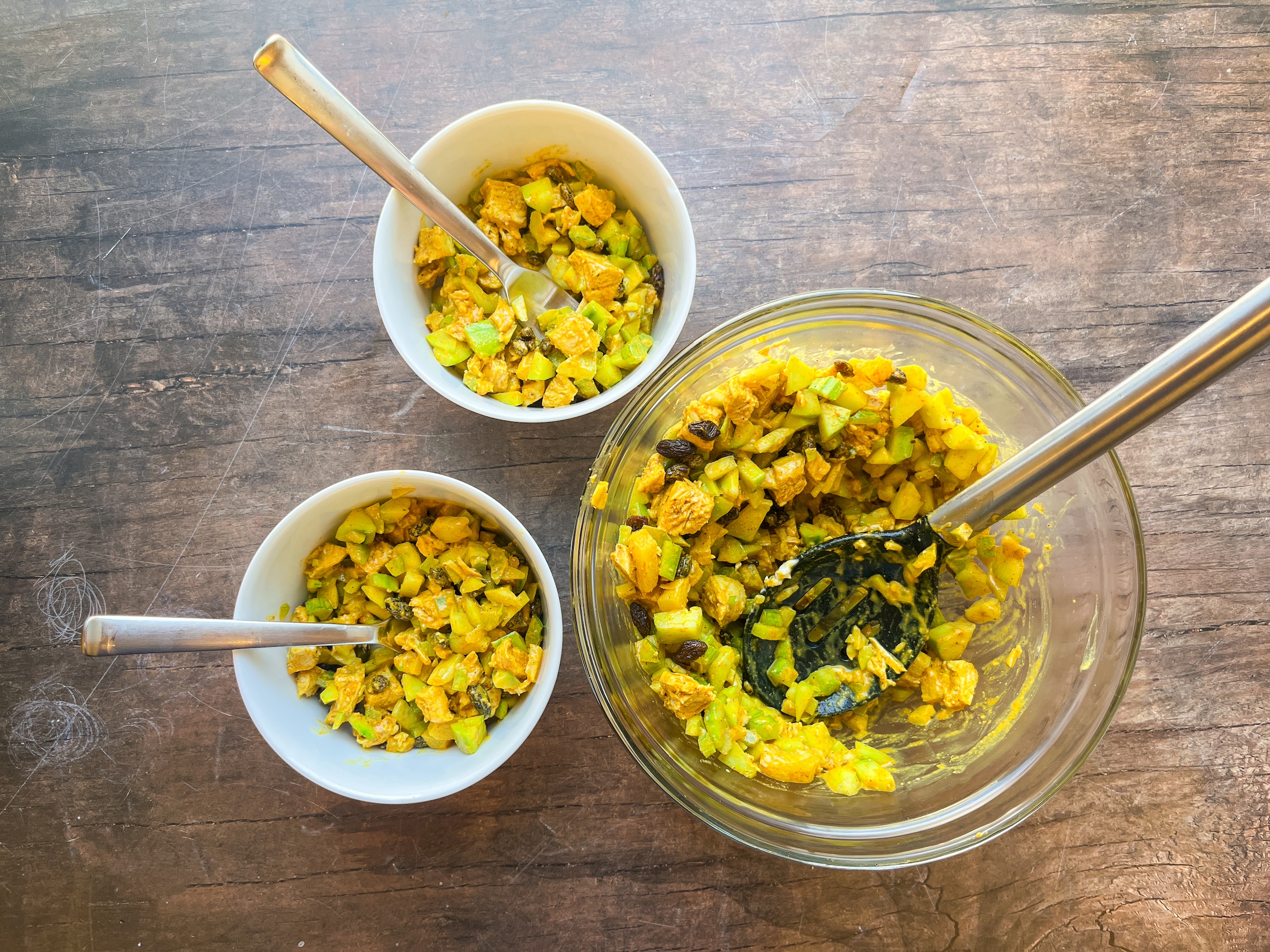 Bombay curry chicken salad being plated into bowls.