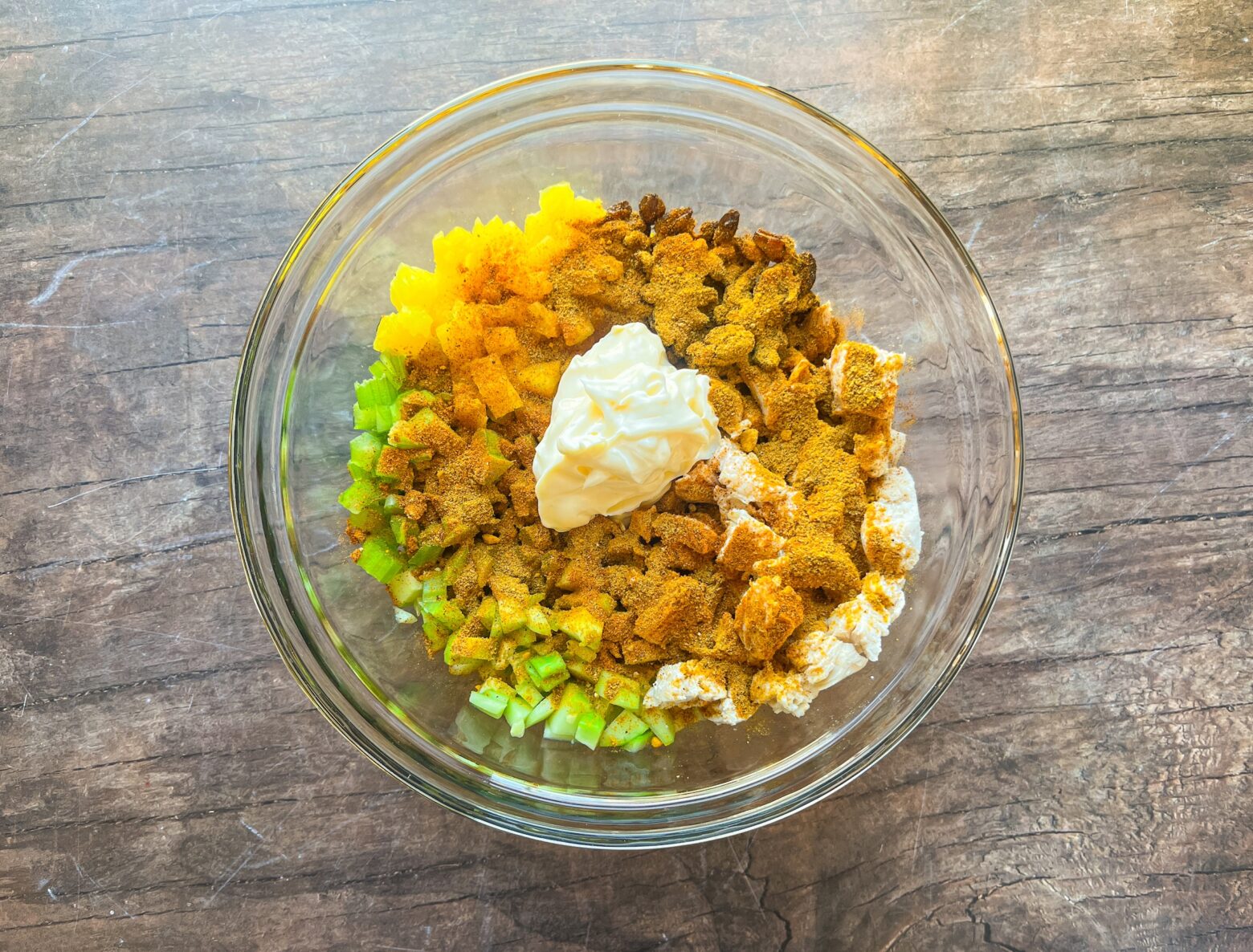 Bombay curry chicken salad in a large glass bowl, pre-stirred.
