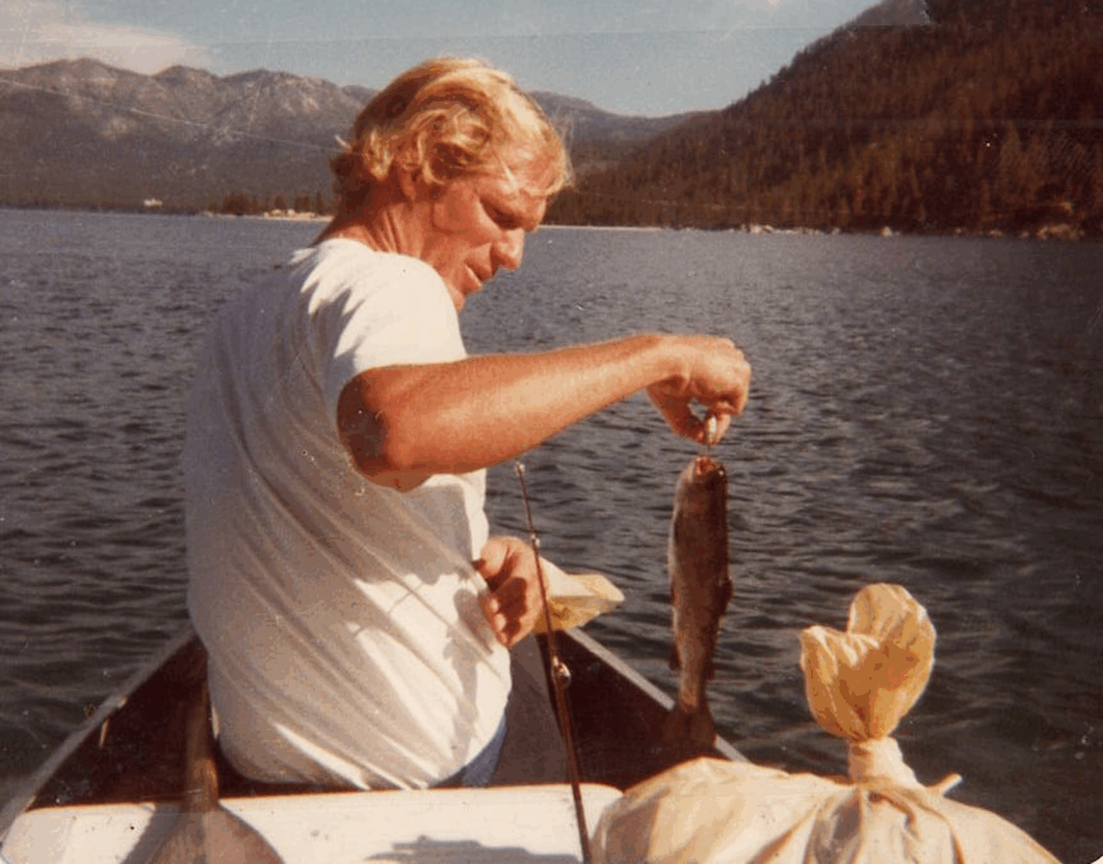 Loren Cordain showing the fish he just caught in his boat.