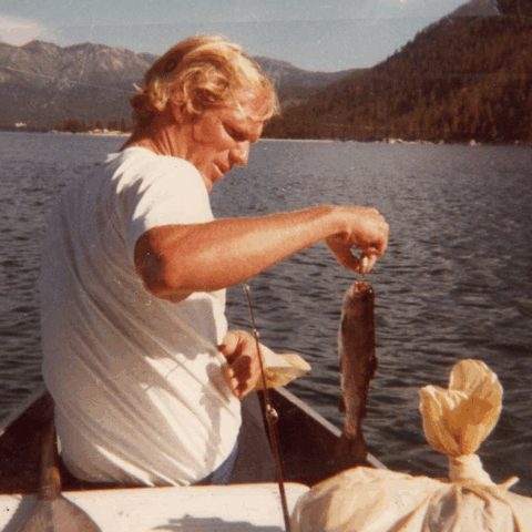 Loren Cordain showing the fish he just caught in his boat.