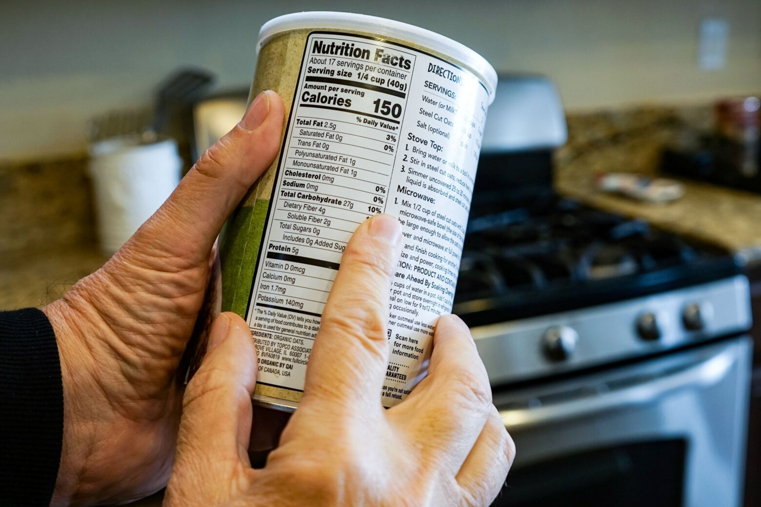 Man examining the nutrition facts label on a container of food.