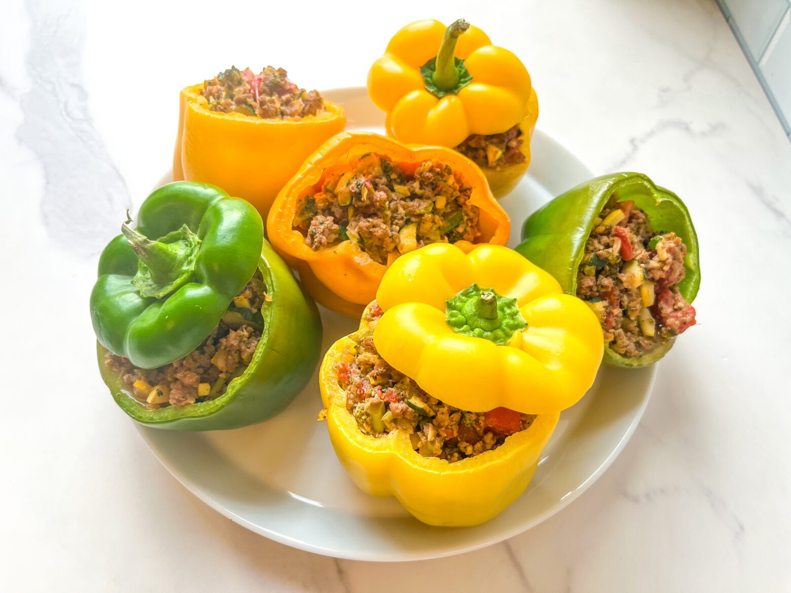 Paleo stuffed peppers on a plate, with the tops.