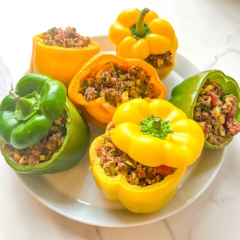 Paleo stuffed peppers on a plate, with the tops.