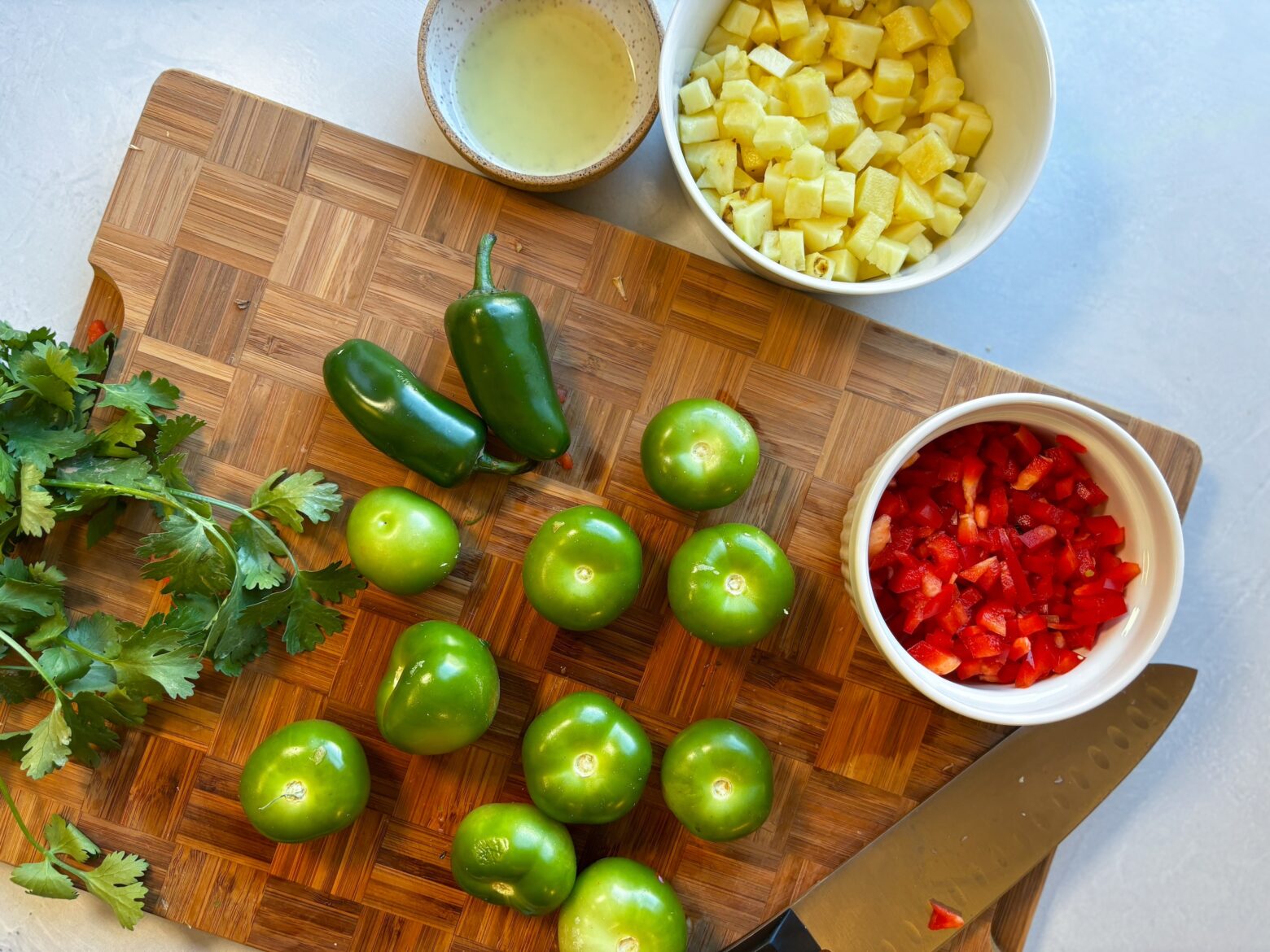 Grilled pineapple salsa verde prep on a cutting board.