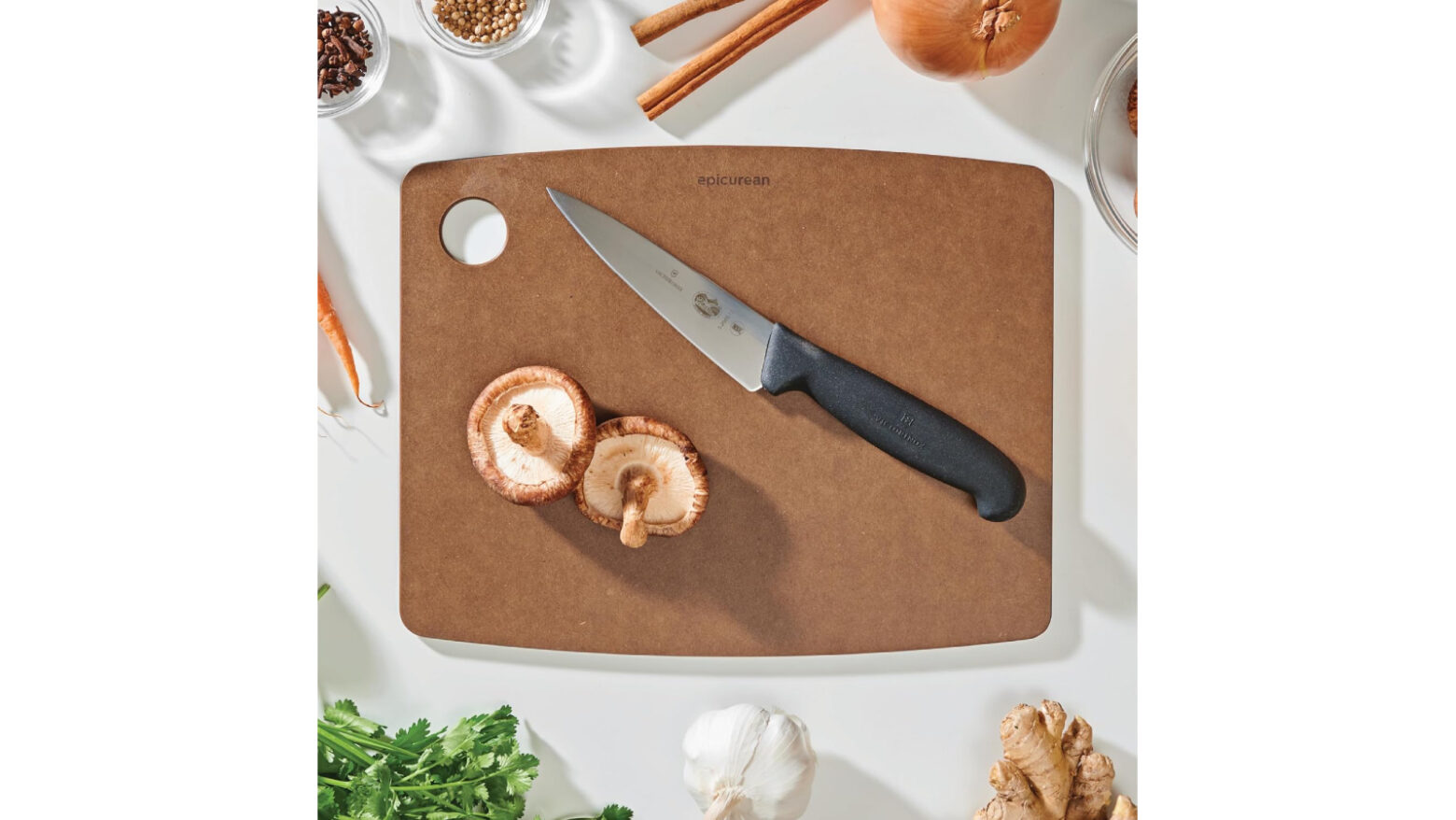 Above shot of an Epicurean cutting board with food surrounding it.