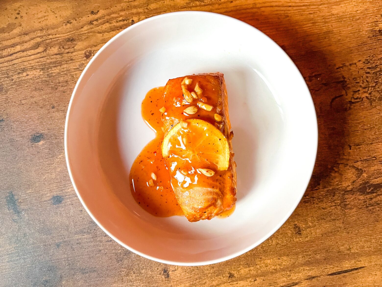 Cedar plank grilled salmon finished with sauce on top.
