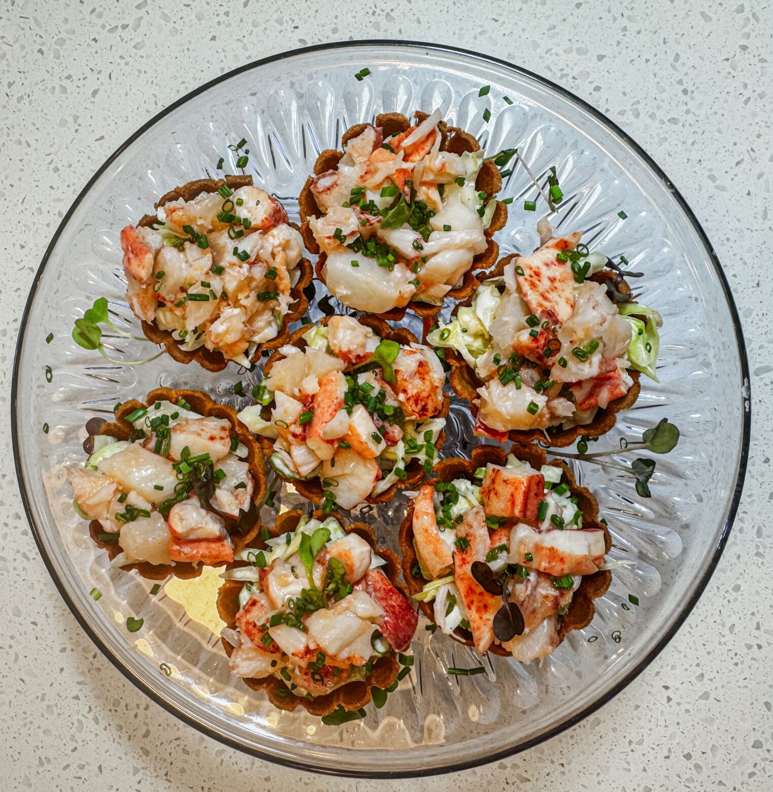 Lobster rolls on a clear platter.