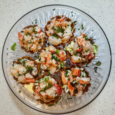 Lobster rolls on a clear platter.