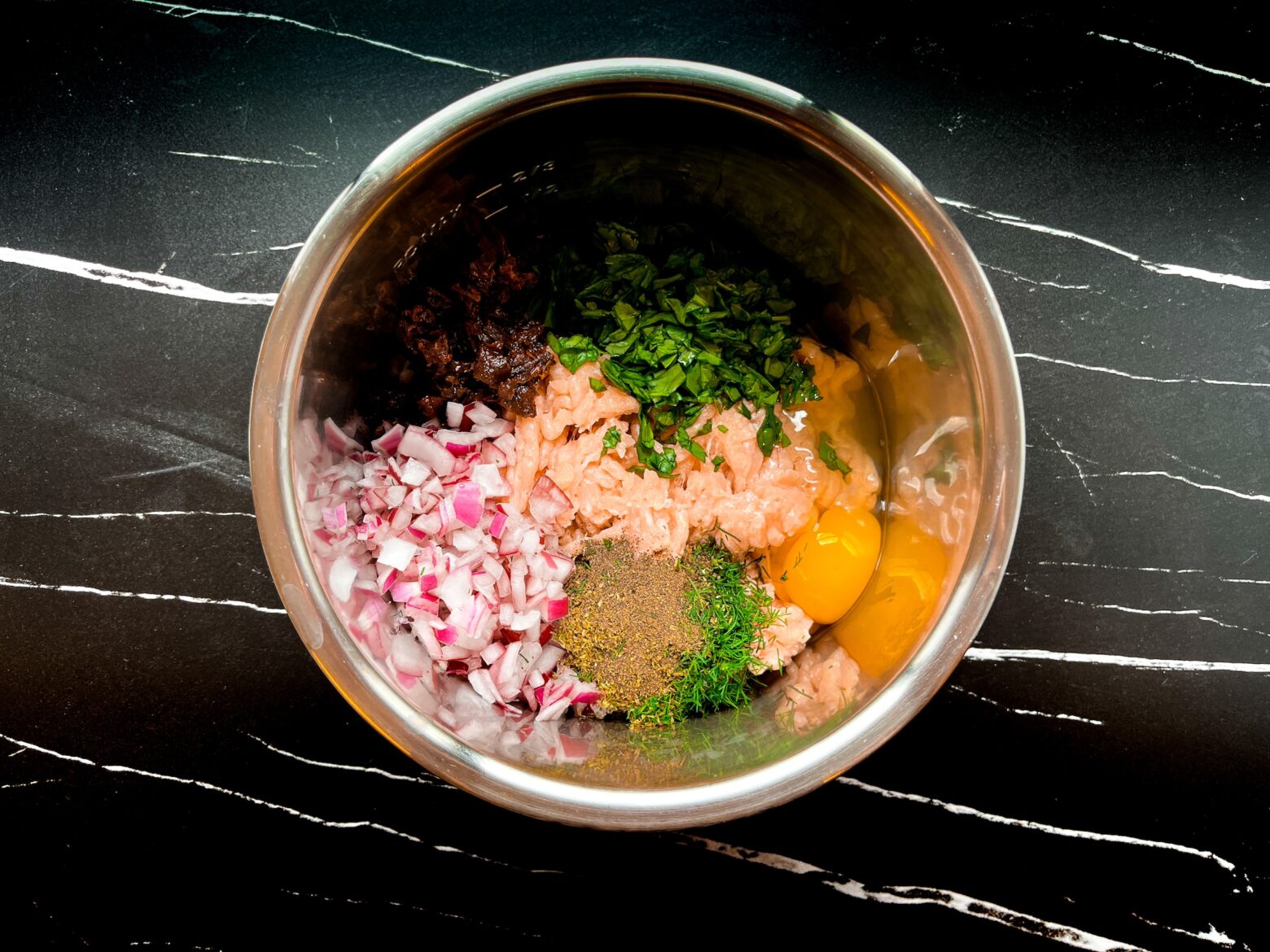 Mediterranean chicken meatball batter being prepped in a bowl.