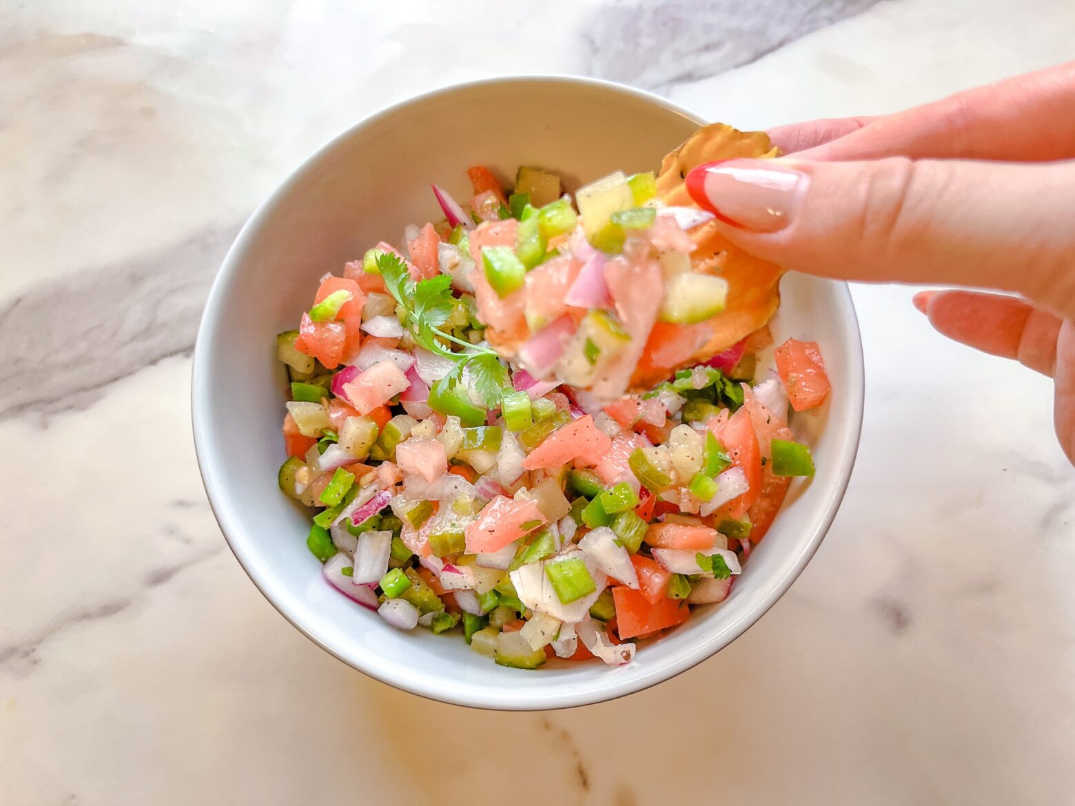 Pickle de gallo finished with a chip being dipped.