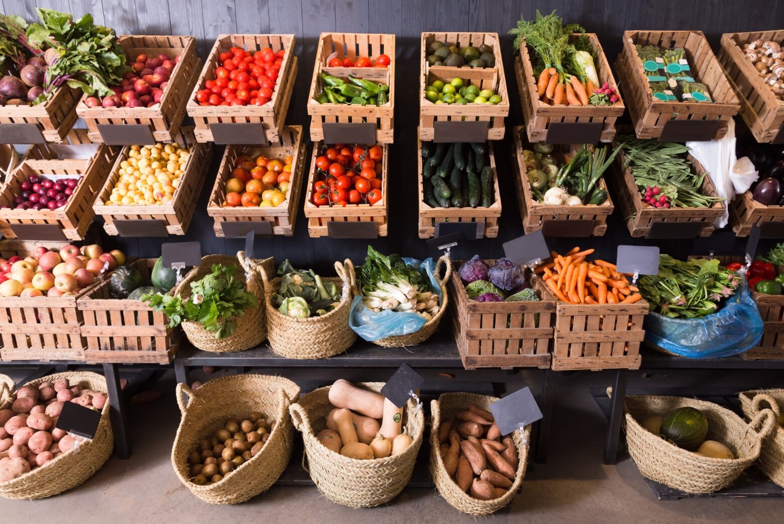 A stand of fresh fruits and vegetables in baskets