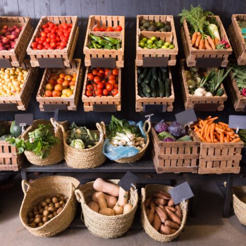 A stand of fresh fruits and vegetables in baskets