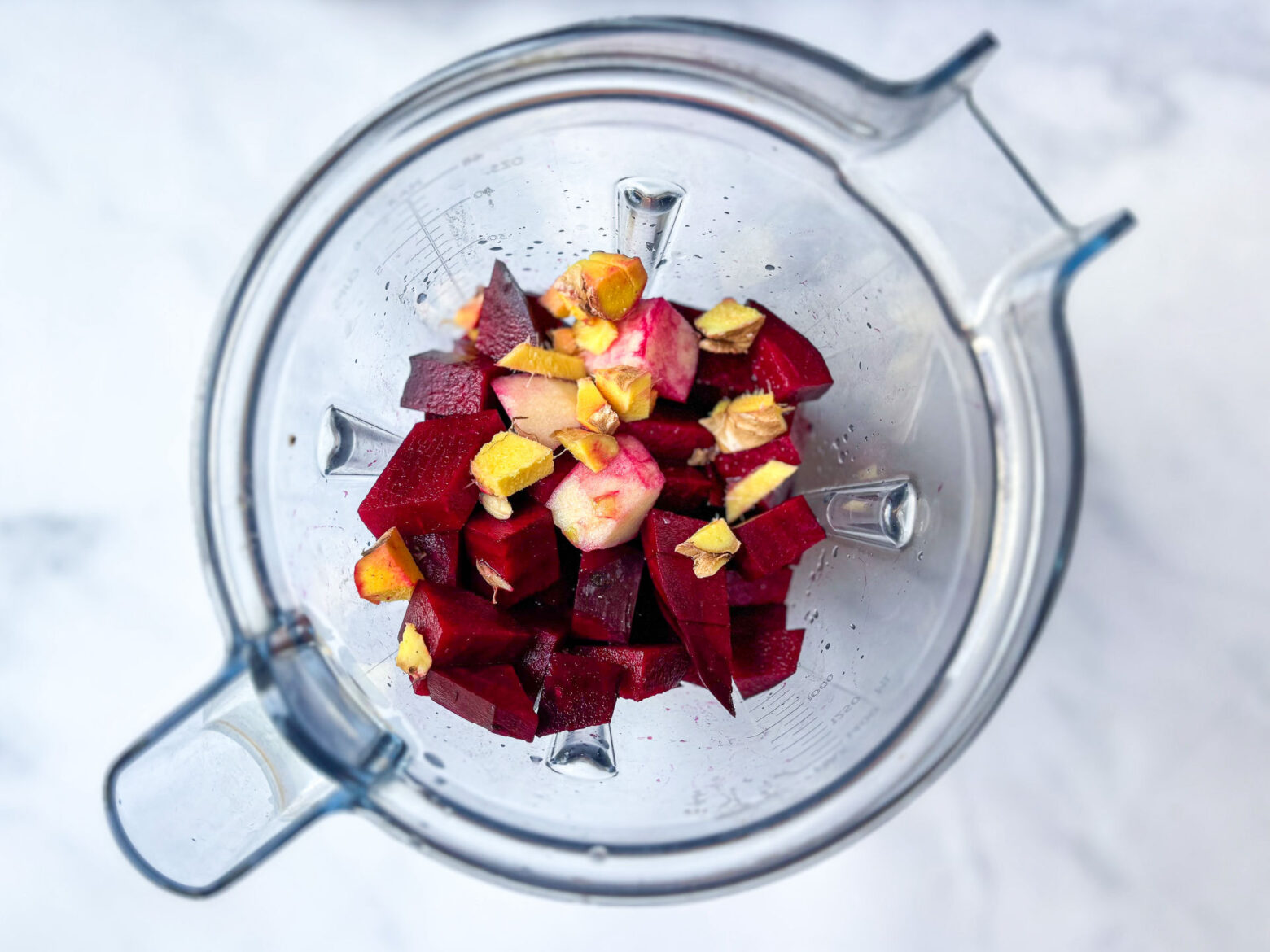 Blender with chopped up beet juice ingredients, pre blend.