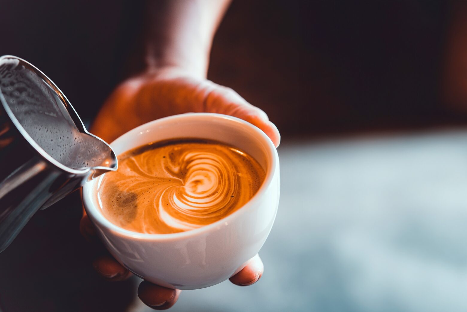 Close-up of a barista making latte art.