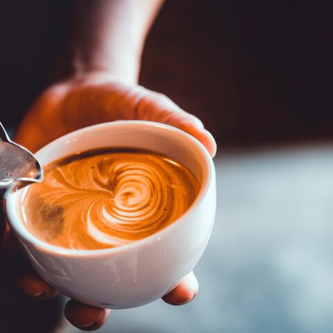 Close-up of a barista making latte art.