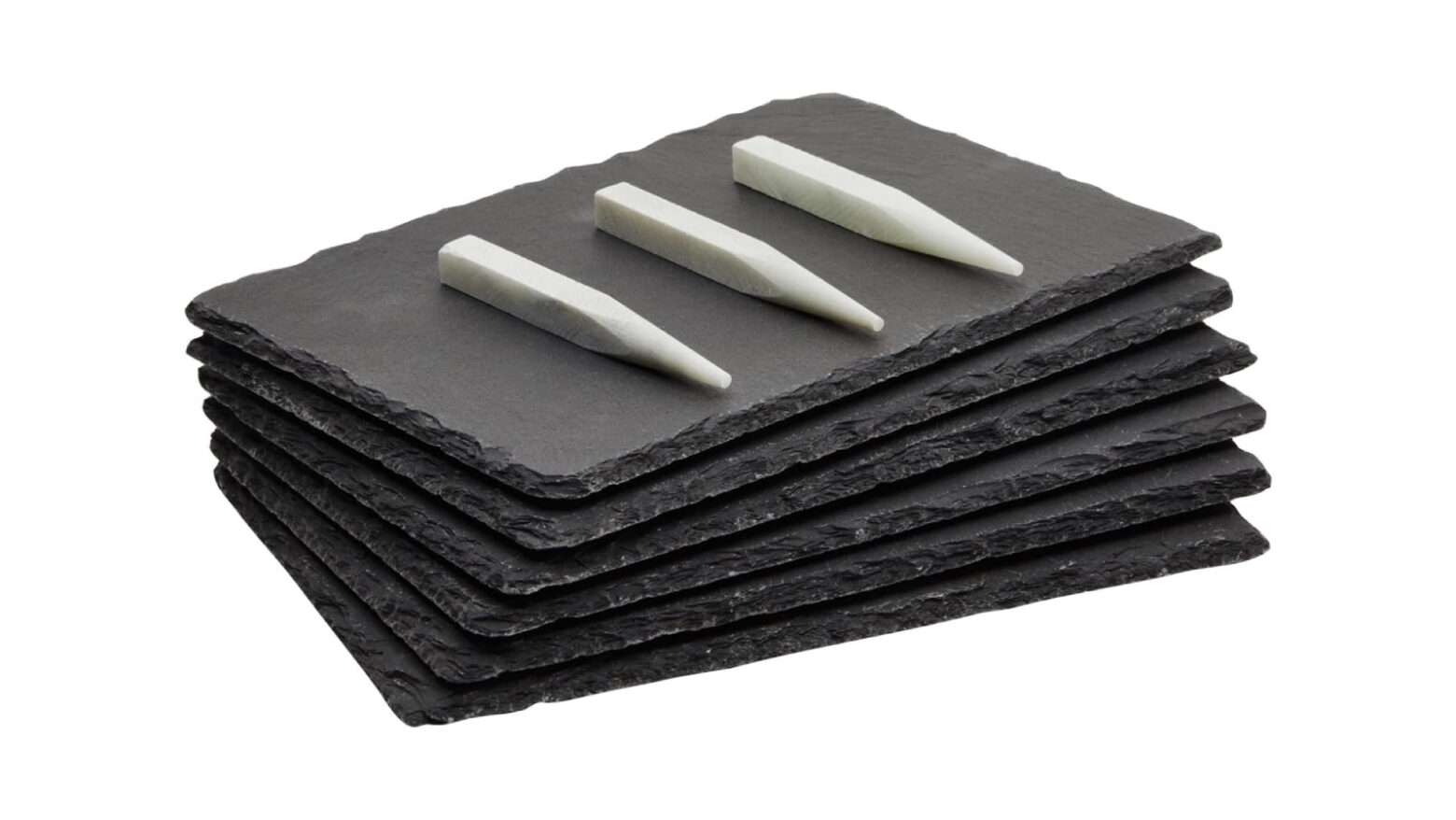Stack of slate serving boards with writing chalk.