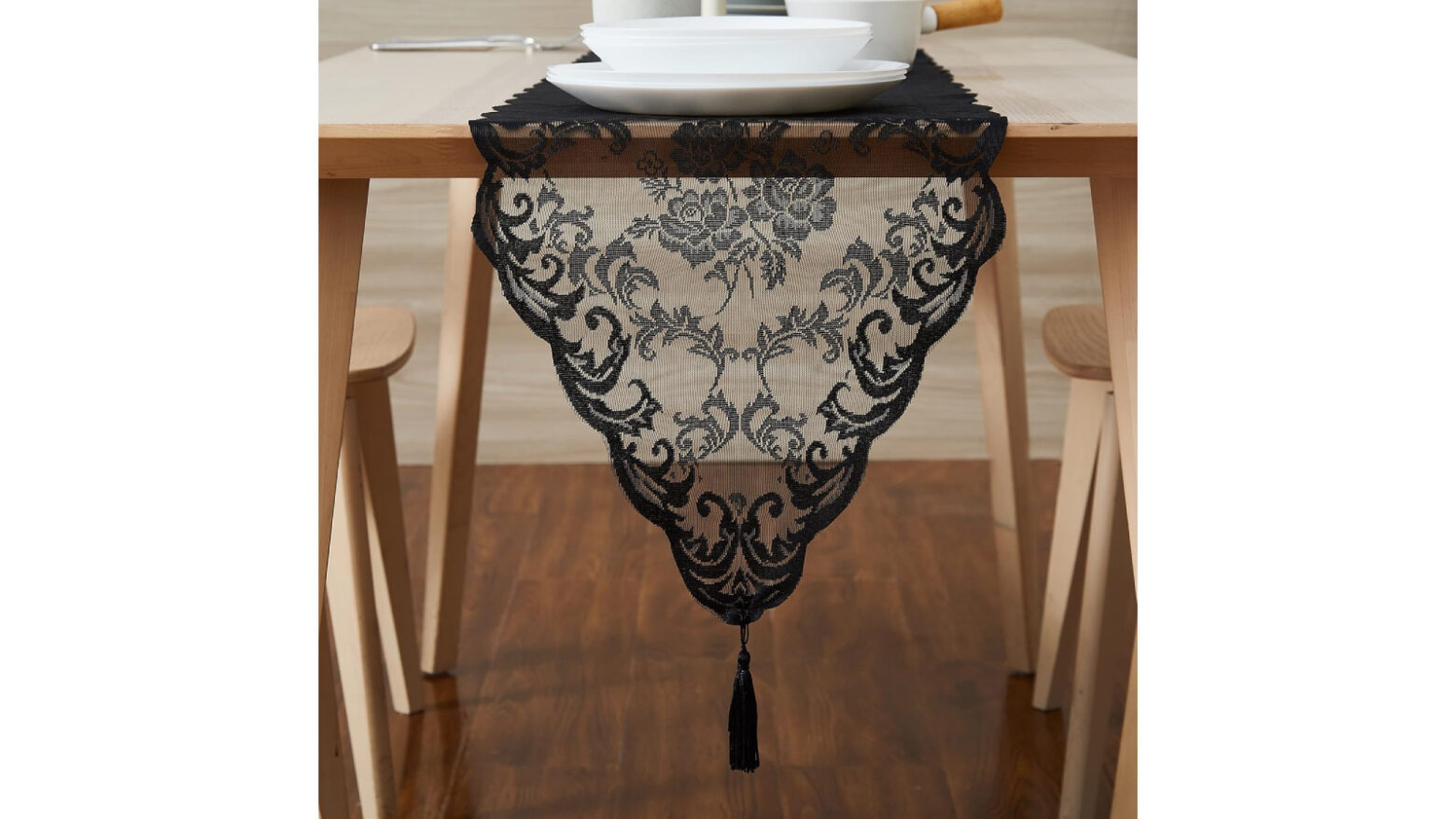 Gothic lace-style black table runner with tassel embellishment.