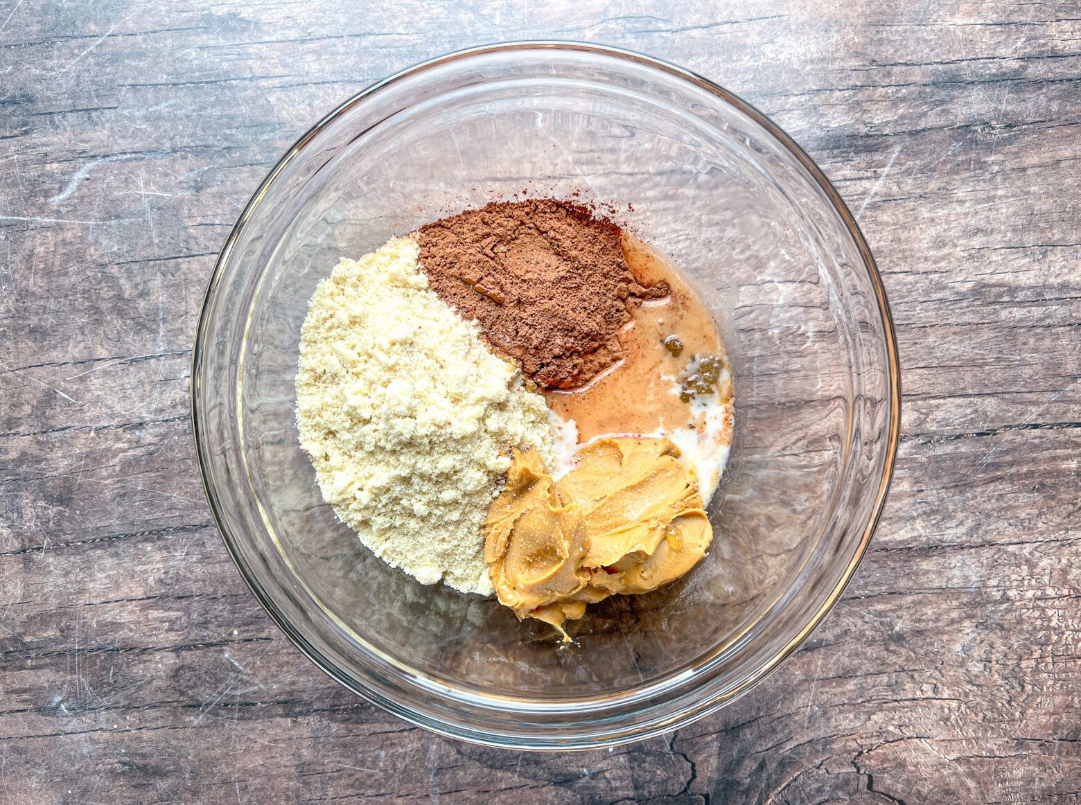 Homemade brownie bars mixing base layer in a glass bowl.