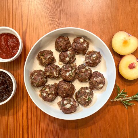 Bison meatballs finished with side sauces.