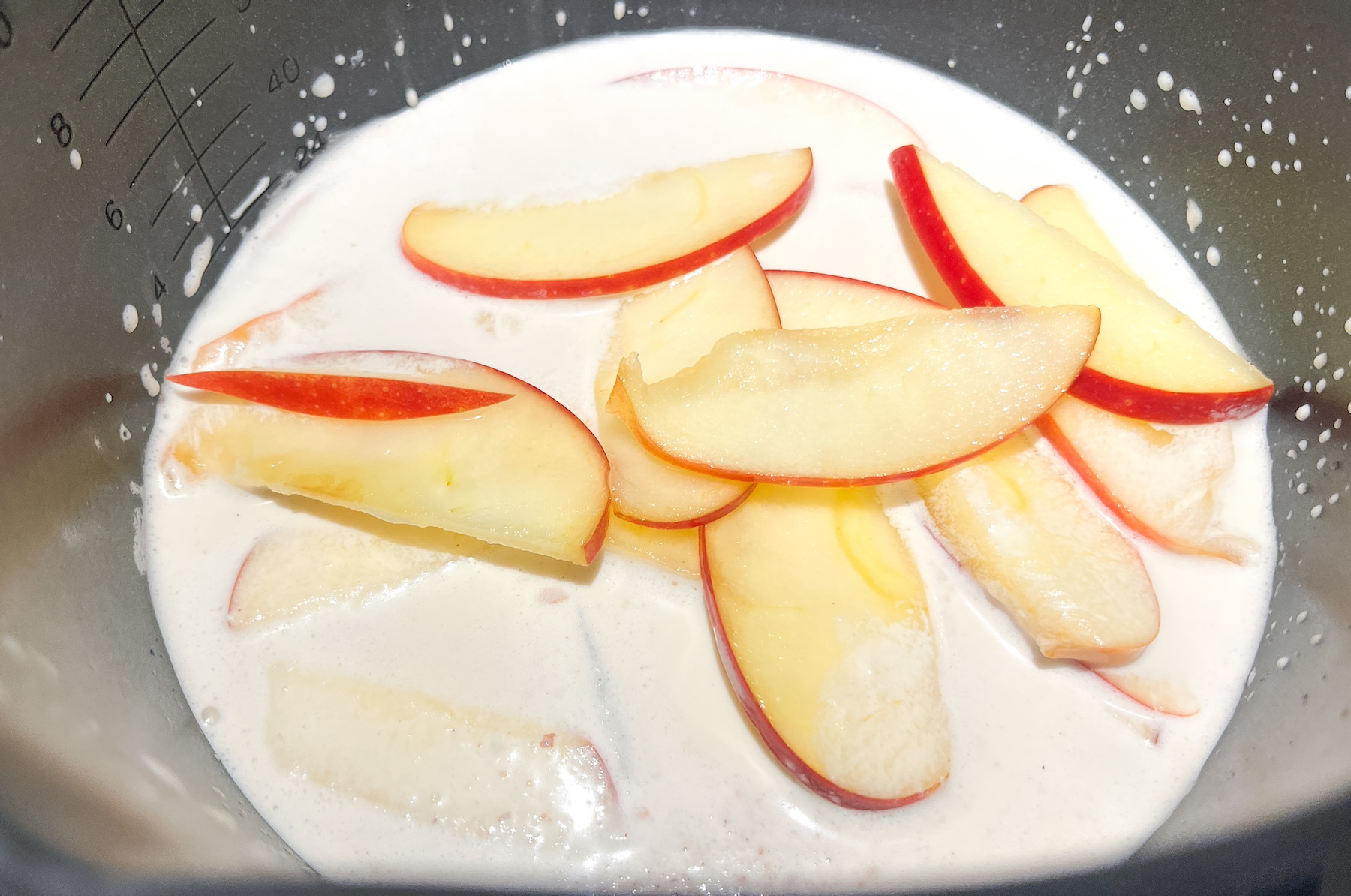 Apple pie spiced almond milk with milk cooking in a pan.
