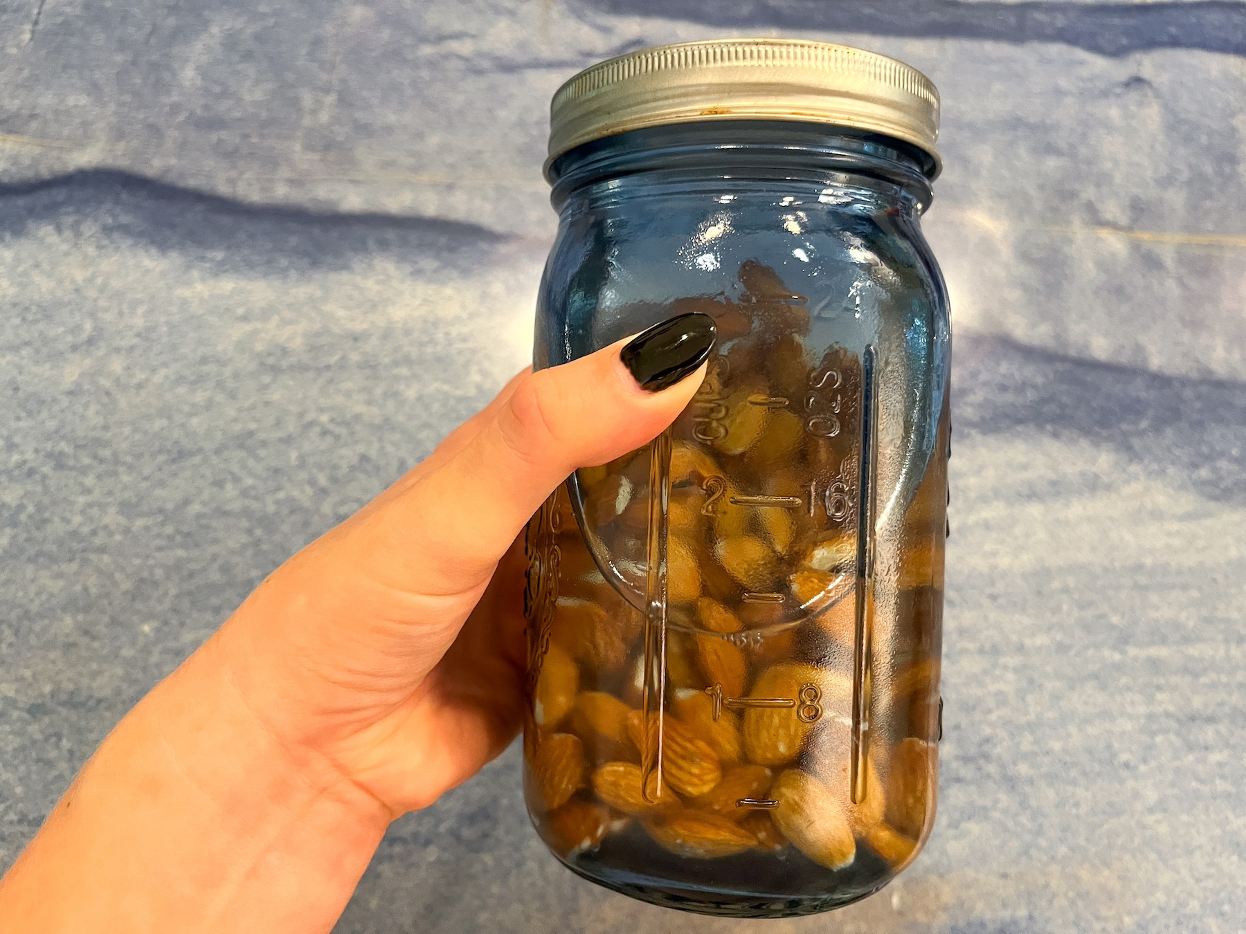 Apple pie spiced almond milk prepping water in a mason jar with almonds.